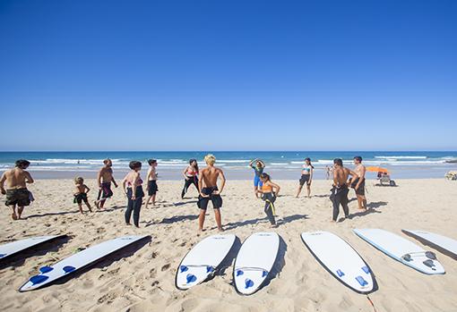 Un grupo de principantes al comienzo de una clase para practicar surf en El Palmar