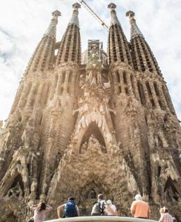 Varios turistas observan la fachada principal de la Sagrada Familia